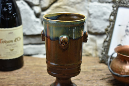Handmade ceramic chalice with skulls - brown/green effect glaze