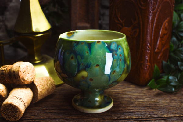 Handmade ceramic cup with shiny green effect glaze