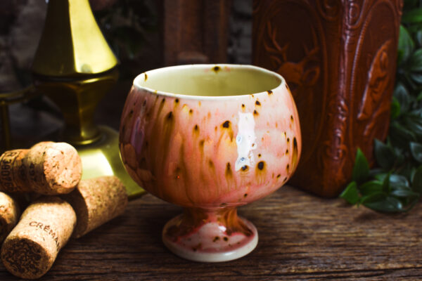 Handmade round ceramic cup with shiny pink effect glaze